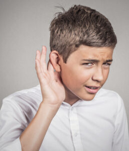 Hard of hearing man placing hand on ear asking to speak up